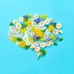 Image of flowers forming the shape of a brain to represent mental health and wellness.