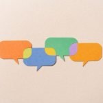 Paper Craft Multi Colored Speech Bubbles Connected With Shared Options on Beige Background Directly Above View.