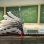 Open laptop and book on a desk, edtech